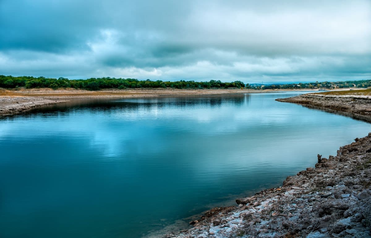 A calm Central Texas river under a cloudy sky