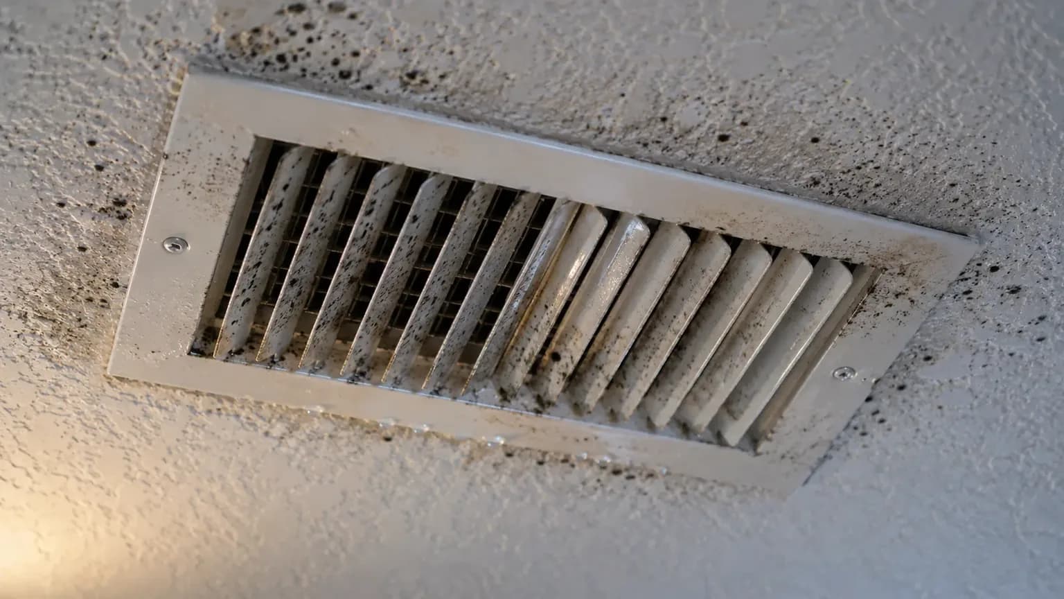 Dark spotting around a ceiling air conditioning supply vent in a humid San Marcos, TX home